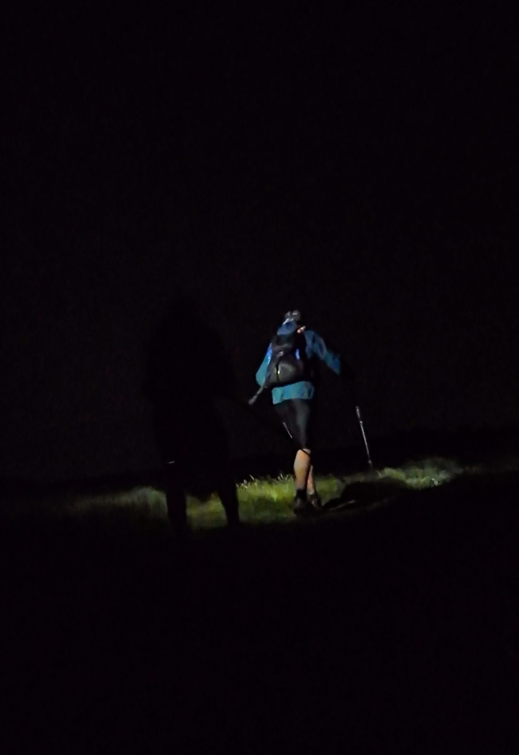 Runners crossing exposed moorland at night during the Stanza Stones Ultra